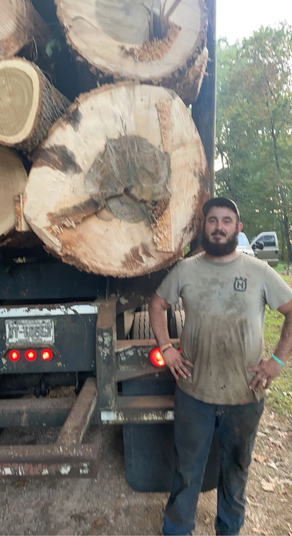 Dakota, owner of Southern Solutions, on a North Carolina job site with a loaded log truck